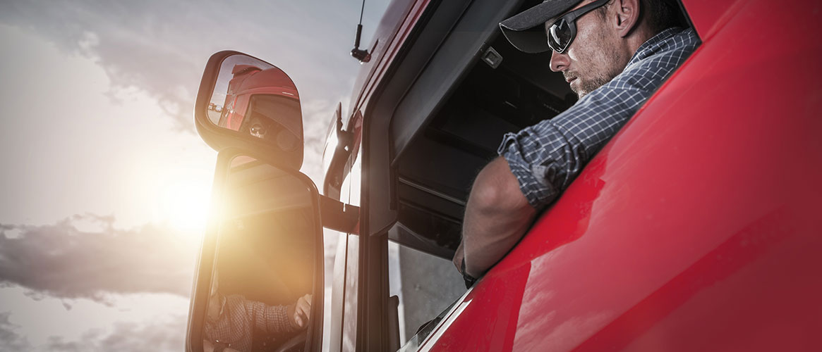 Truck driver with open window and bare forearm exposed to the sun