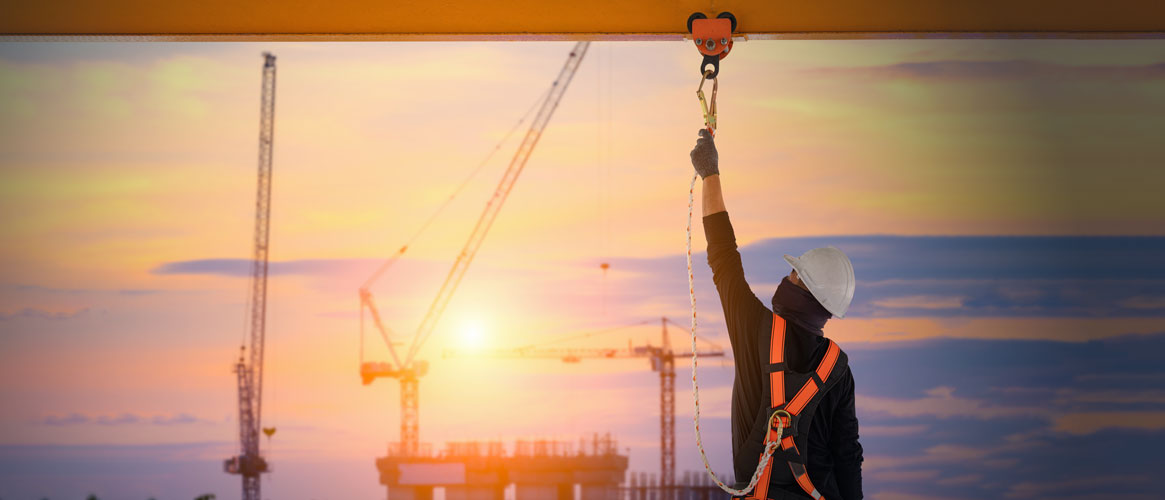 Construction worker connecting to fall protection Construction worker connecting to fall protection