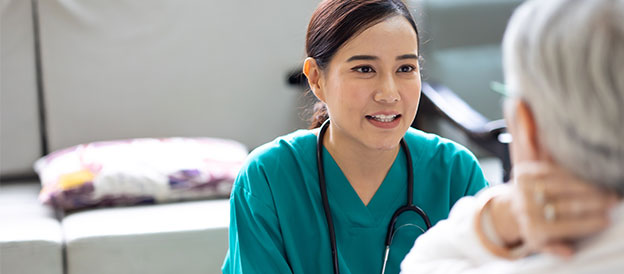 Caregiver talking with elderly patient
